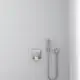Brausearmatur von Ideal Standard, minimalistisches Design, montiert an einer hellen Wand, mit einem integrierten Handbrausekopf und flexibler Schlauchverbindung.
